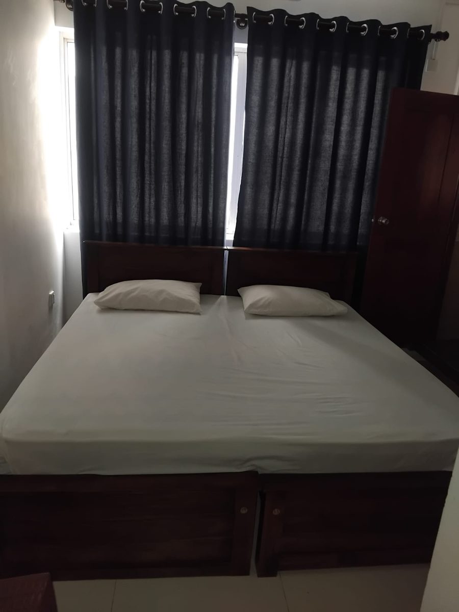 Double bedroom with a window, curtains and wardrobe