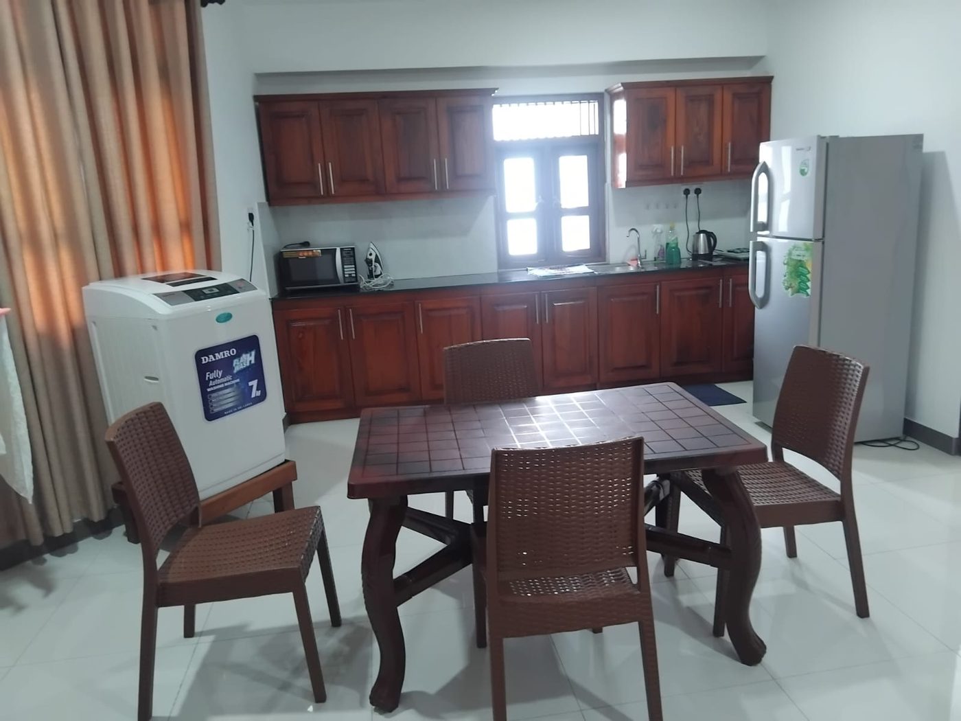 Kitchen and dining area with fridge, microwave, kettle and washing machine